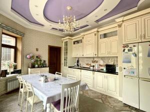 a kitchen with a table and a purple ceiling at Kurak Homestay in Bishkek