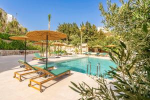 a swimming pool with two chairs and umbrellas and a swimming pool at Chambre avec vue panoramique in Noûnouech