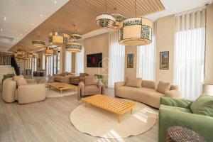 a living room with couches and tables and chandeliers at Chambre avec vue panoramique in Noûnouech