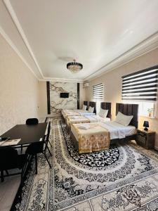 a bedroom with two beds and a table and a dining room at Guest House Bekturdi in Khiva