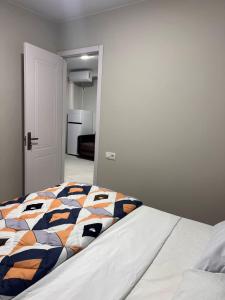 a bed with a colorful blanket on it in a room at Comfortable 5 rooms apartment in Kutaisi