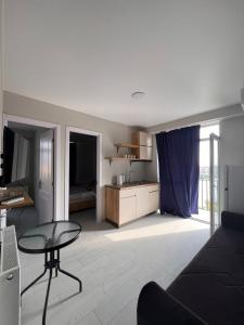 a living room with a table and a kitchen at Comfortable 5 rooms apartment in Kutaisi