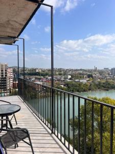 a balcony with a table and chairs and a river at Comfortable 5 rooms apartment in Kutaisi