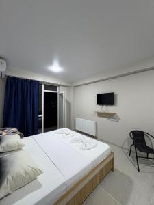 a bedroom with a large white bed and a chair at Comfortable 5 rooms apartment in Kutaisi