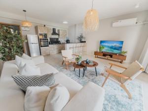 a living room with a white couch and a table at Sandy Shore Beach Apartments - Karibu Quarters in Kikambala