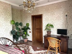 a living room with a desk and potted plants at Kurak Homestay in Bishkek