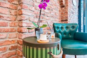 a coffee table with a chair and a purple flower on it at Taksim Artelist Hotel in Istanbul