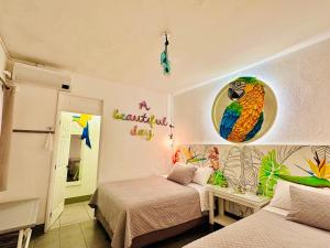 a bedroom with two beds and a parrot on the wall at Hotel y Arte Antigua by Amazing Guatemala Travel in Antigua Guatemala +49 photos