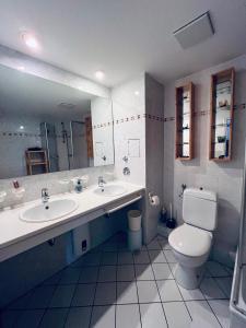 a bathroom with two sinks and a toilet and a mirror at Ocean View Laboe in Laboe