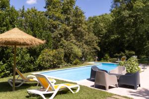 a group of chairs and an umbrella next to a swimming pool at Geres parque in Geres