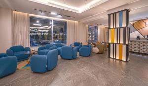 a waiting area with blue chairs and tables in a building at Ewaa Express Hotel - Yanbu Alamarah in Yanbu