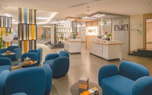 a waiting room with blue chairs and a counter at Ewaa Express Hotel - Yanbu Alamarah in Yanbu