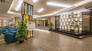 a lobby with blue chairs and potted plants at Ewaa Express Hotel - Yanbu Alamarah in Yanbu