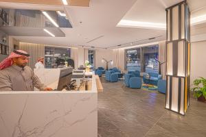 a man sitting at a desk in an office at Ewaa Express Hotel - Yanbu Alamarah in Yanbu +40 photos