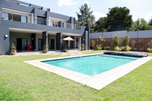 a swimming pool in front of a house at Real Kee in Midrand