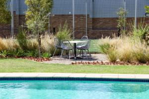 a table and chairs next to a swimming pool at Real Kee in Midrand