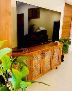 a flat screen tv sitting on top of a wooden entertainment center at Cairo in Siolim