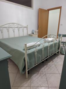 a bedroom with a bed with a green comforter at Casa Kate in Scanzano