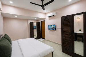 a bedroom with a bed and a flat screen tv at StayLuxe Rooms & Apartments Near BKC, Chembur in Mumbai