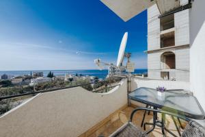 a balcony with a table and a view of the ocean at Studio Apartments S in Dobra Voda