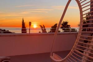 a view of the sunset from a balcony with a hammock at Casa del Sol Jacuzzi privado y vistas al Mediterráneo en Altea Hills in Altea