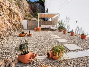 a patio with potted plants on a gravel ground at Casa del Sol Jacuzzi privado y vistas al Mediterráneo en Altea Hills in Altea +24 photos