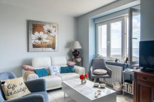 a living room with a couch and a table at La Rose des Mers in Tréffiagat
