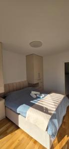 a bedroom with a large bed with blue sheets at Sunlit Oasis Garden in Postojna