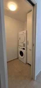 a laundry room with a washing machine and a washer at Sunlit Oasis Garden in Postojna