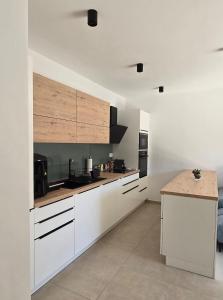 a kitchen with white cabinets and a wooden counter top at Sunlit Oasis Garden in Postojna