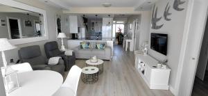 a living room with a couch and a tv at Dolphin Beach H203 Table Mountain Views in Bloubergstrand