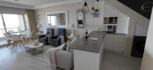 a kitchen and living room with a couch and a table at Dolphin Beach H203 Table Mountain Views in Bloubergstrand