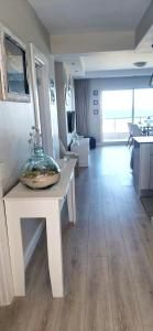 a living room with a table with a vase on it at Dolphin Beach H203 Table Mountain Views in Bloubergstrand