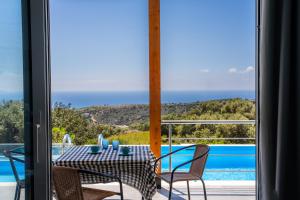 a table and chairs with a view of a pool at Vrachos Nature Lodges DAPHNE 2, Private pool in Agia Galini