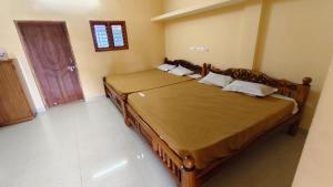 a bedroom with a large bed in a room at Priyan Beach View Residency in Kuilapayam