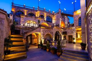 a large stone building with a staircase in a courtyard at Aurelia Cave Cappadocia - Special Class in Nevşehir +21 photos