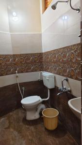 a bathroom with a toilet and a sink at Priyan Beach View Residency in Kuilapayam
