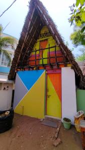 a colorful house with a thatched roof at Priyan Beach View Residency in Kuilapayam +12 photos