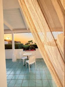 a patio with a table and chairs on a balcony at Borgo di Riaci Beach Resort in Santa Domenica