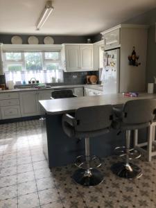 a kitchen with a counter and two bar stools at Wellfield house in Wexford