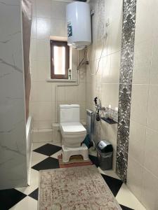 a bathroom with a white toilet and a window at Kurak Homestay in Bishkek +26 photos