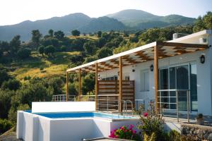 a house with a swimming pool and mountains in the background at Vrachos Nature Lodges DAPHNE 2, Private pool in Agia Galini