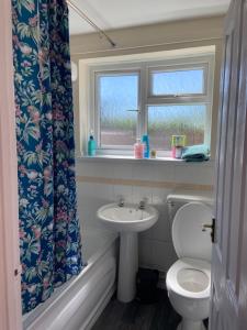 a bathroom with a sink and a toilet and a window at Town Centre House Sleeps 8 with parking in Stafford +14 photos