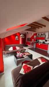 a living room with red walls and a kitchen at Rožu romantika in Cēsis