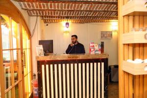 a man talking on a cell phone behind a counter at Hatay Hotel in Istanbul