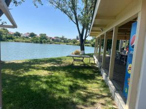 a picnic table on the side of a house with a lake at LAGUNA VERDE Balotesti in Baloteşti