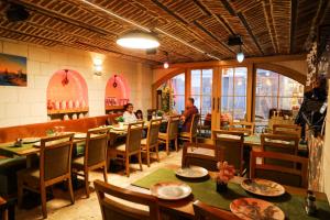 a restaurant with tables and chairs and people sitting at them at Hatay Hotel in Istanbul