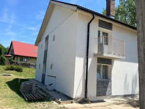 a white house with a balcony on the side of it at LAGUNA VERDE Balotesti in Baloteşti +85 photos