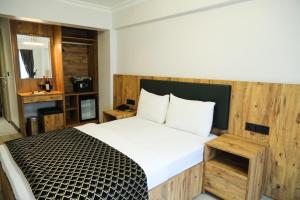 a bedroom with a large bed with a wooden headboard at Hatay Hotel in Istanbul +42 photos