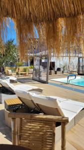 a resort with a pool and chairs and a straw umbrella at Kopań Kabana in Darłowo